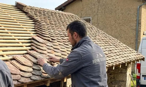 Tuiles écailles posées rang par rang sur des liteaux neufs par un couvreur de Bièvre Toitures